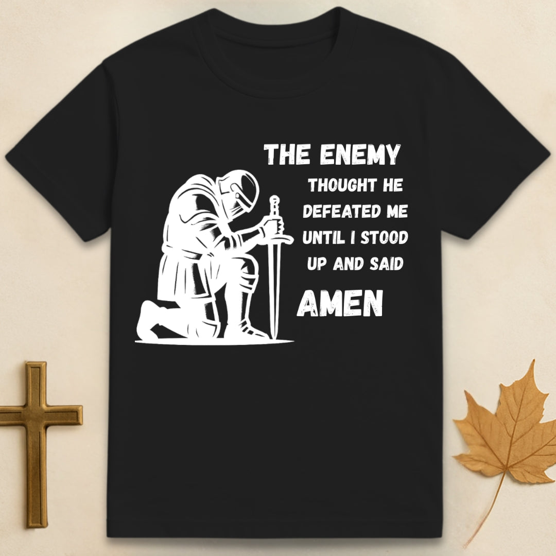 Black Amen t-shirt featuring kneeling soldier graphic with sword planted in the ground and text "The enemy thought he defeated me until I stood up and said Amen"