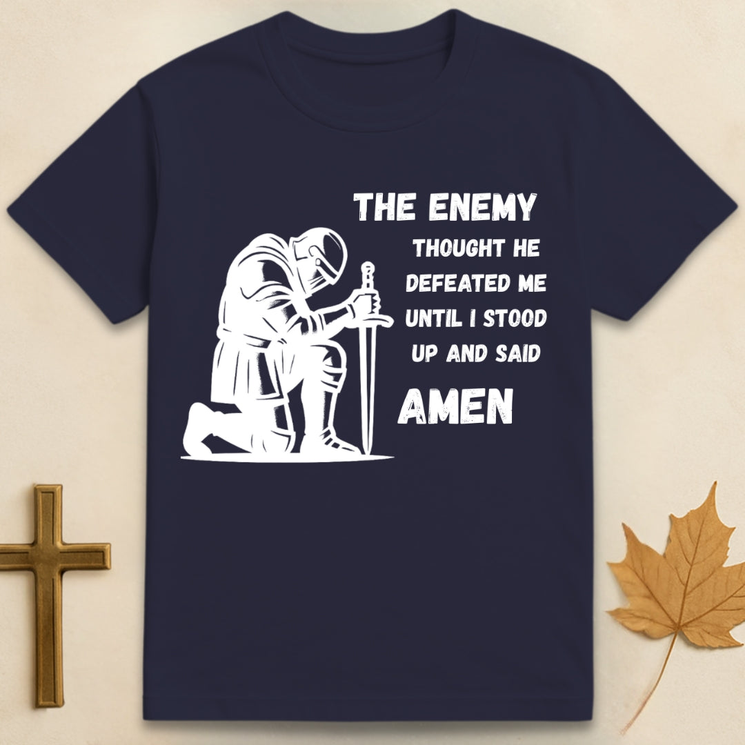 Navy blue Amen t-shirt featuring kneeling soldier graphic with sword planted in the ground and text "The enemy thought he defeated me until I stood up and said Amen".